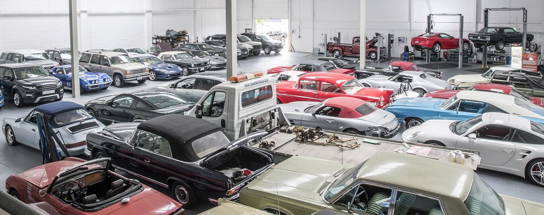 Busy ShipMyCar workshop with technicians working on imported cars.