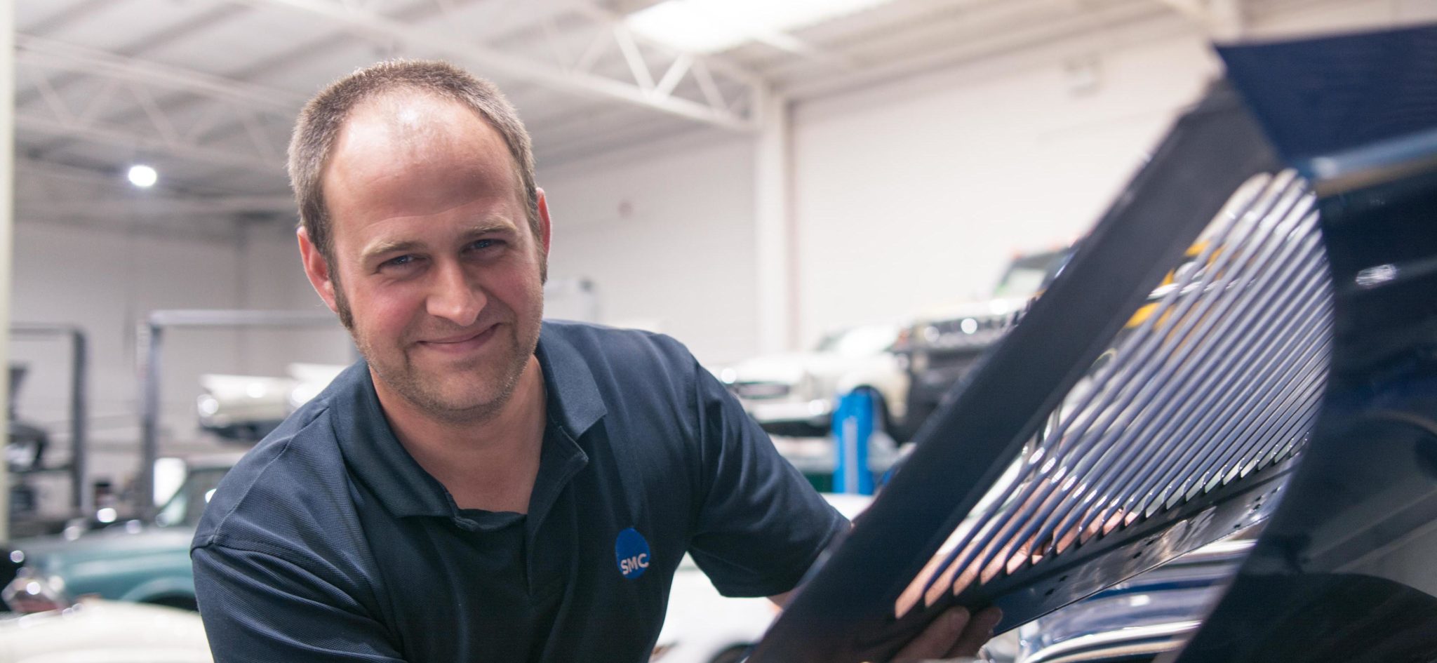 Experienced technician meticulously working on a classic car at ShipMyCar.