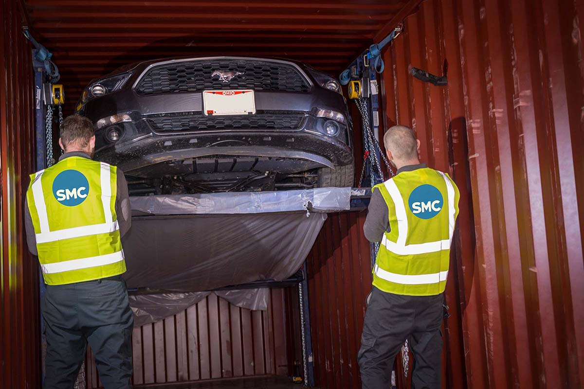 Professional car unloading from container at ShipMyCar facility in Milton Keynes